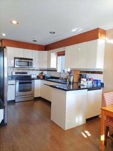 a kitchen with white cabinets and a black counter top at LLT HomeAway in Vancouver