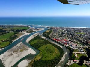an aerial view of a river next to the ocean at Revell St Beach Bungalow in Hokitika
