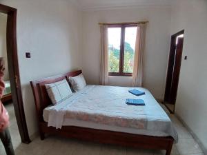 a bedroom with a large bed with a window at Hotel MBC Ruteng in Ruteng