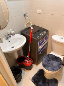 a bathroom with a mop and a toilet and a sink at Makati SM Jazz Residence Staycation Condo with balcony in Manila
