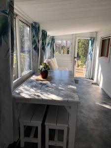 einen großen weißen Tisch in einem Zimmer mit Fenstern in der Unterkunft BUNGALOW 60 M2 in Roquebrune-sur-Argens
