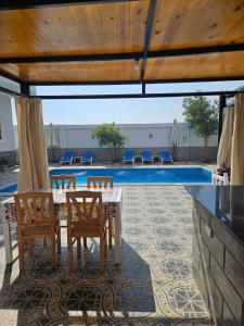uma mesa e cadeiras em frente a uma piscina em Panorama Hotel em Luxor