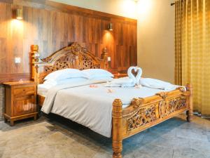 a bedroom with a large bed with a swan on it at Bayshore Villa in Candidasa