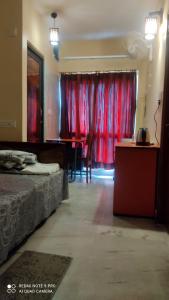 um quarto com uma cama e uma cortina vermelha em The Tulip Touch for Couples. em Calcutá