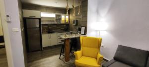 a living room with a yellow chair and a kitchen at The Boutique Hotel Amman in Amman
