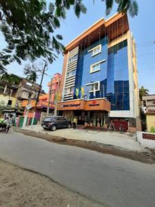 a blue building with a car parked in front of it at Hotel Swagat , Dhubri in Dhuburi