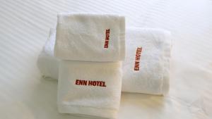 three towels with the words emm hotel on them at Enn Business Hotel in Kampala