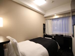 Postel nebo postele na pokoji v ubytování APA Hotel Toyama Ekimae