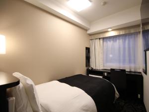 a hotel room with a bed and a window at APA Hotel Toyama-Ekimae in Toyama