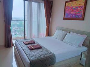 KejayanにあるTHE CABIN APARTMENT PATRALAND AMARTAのベッドとタオル2枚のある寝室