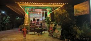 a person walking in front of a building at night at Monica Guesthouse in Kampot