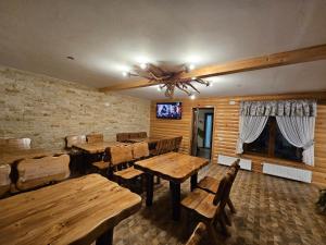 a dining room with wooden tables and chairs and a tv at Pensiunea Ana Maria Durau in Durau
