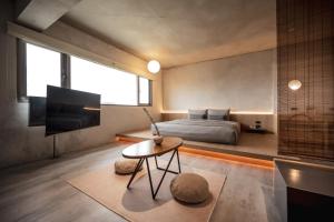 1 dormitorio con cama, mesa y TV en 宜蘭東旅 en Yilan City