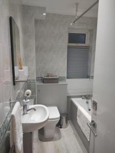 een badkamer met een wastafel, een toilet en een bad bij Sheffield meadowhall interchange house with off street parking in Sheffield