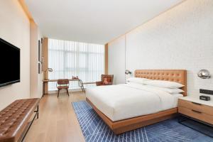 een slaapkamer met een groot bed en een televisie bij Four Points by Sheraton Xi’an High-Tech Zone in Xi'an