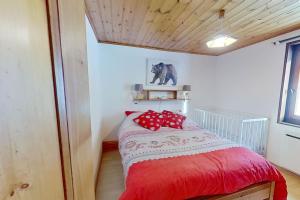 een slaapkamer met een bed met rode kussens erop bij CASA-La Carotto Apart in chalet Saint Veran in Saint-Véran
