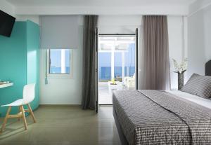 a bedroom with a bed and a view of the ocean at Coral Hotel in Ierápetra
