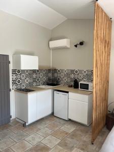 a kitchen with white cabinets and a counter top at Gîte La maison dans l'Olivette in Oraison