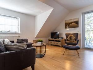 a living room with a couch and chairs and a tv at Luxury holiday apartment in St Peter Ording in St. Peter-Ording