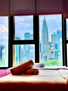 Bett in einem Schlafzimmer mit Stadtblick in der Unterkunft Ceylonz Suites KL City by One39KL in Kuala Lumpur