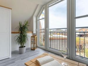 a living room with large windows and a view of the ocean at Ferienwohnung in St Peter Ording in Sankt Peter-Ording