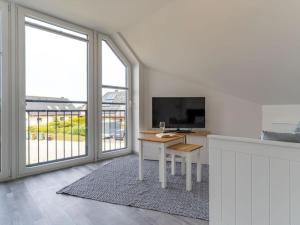 a white room with a table and a tv and a window at Ferienwohnung in St Peter Ording in Sankt Peter-Ording
