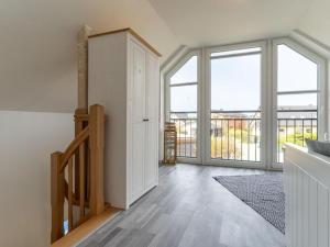 a living room with a staircase and large windows at Ferienwohnung in St Peter Ording in Sankt Peter-Ording +33 photos