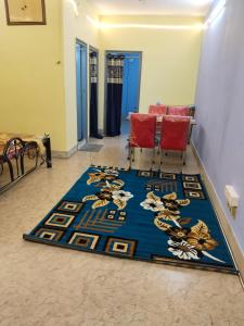 a room with a blue rug on the floor with two chairs at Behala home stay in Kolkata