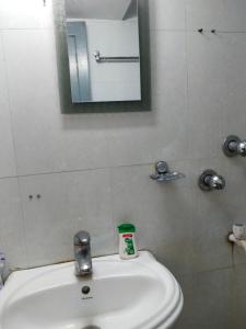 a bathroom with a white sink and a mirror at Behala home stay in Kolkata