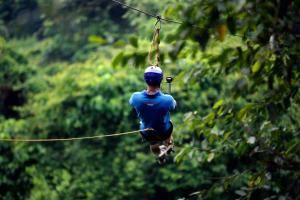 Ein Mann, der auf einer Seilrutsche im Dschungel läuft in der Unterkunft Ceylon Adventure Sports in Kitulgala