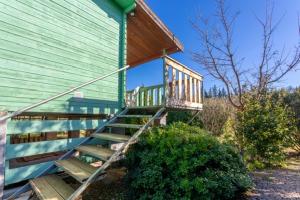 a green house with a staircase on the side of it at Chalets 1 MESANGE BLEUE Roquebrune Sur Argens in Roquebrune-sur-Argens
