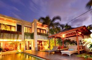 a house with a swimming pool in front of it at Villa Artisane in Seminyak