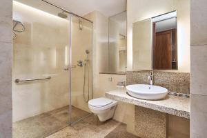 La salle de bains est pourvue de toilettes, d'un lavabo et d'une douche. dans l'établissement Sheraton Towers Singapore Hotel, à Singapour