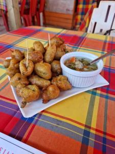 un plato de comida con aros de cebolla y un tazón de sopa en Mariposa en Sainte-Rose