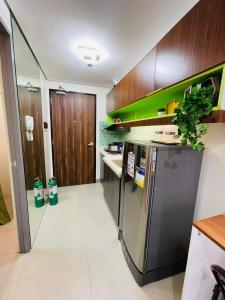 a kitchen with a stainless steel refrigerator and wooden cabinets at Studio 7 in Manila