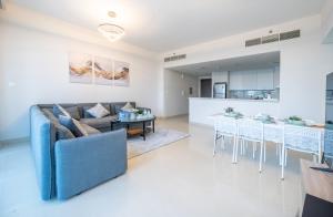 ein Wohnzimmer und eine Küche mit einem Sofa und einem Tisch in der Unterkunft 2BR Apartment in Harbour Views in Dubai