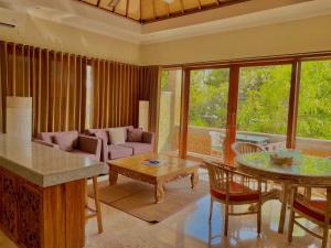 a living room with a couch and a table at Bayshore Residence in Candidasa