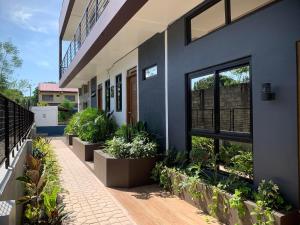 um edifício com vasos de plantas ao lado em JORA LOFT - Japandi inspired apt 1- D em Dagupan