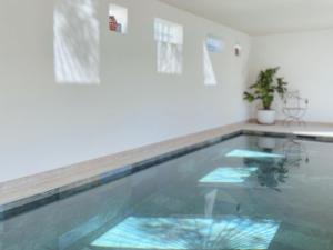a swimming pool with water in a room at La Jabotte in Antibes