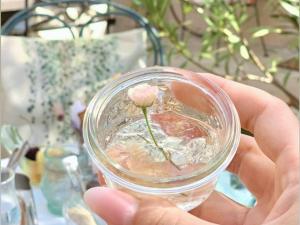 a person holding a glass with a flower in it at La Jabotte in Antibes