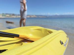 a yellow kayak sitting on the beach with a man in the background at La Jabotte in Antibes