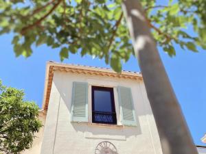 a window on the side of a building with a clock at La Jabotte in Antibes
