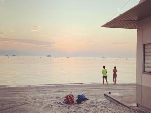 two people standing on the beach looking at the water at La Jabotte in Antibes