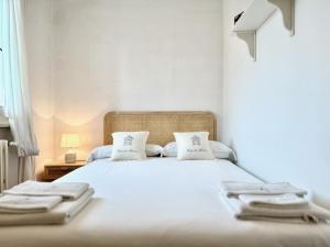 a bedroom with a white bed with two towels on it at Maison Cirì in Forte dei Marmi
