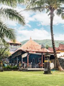 een restaurant met een palmboom en een gebouw bij Bayshore Residence in Candidasa
