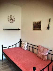 a bed in a room with a clock on the wall at Ubytování Pod lázněmi Klimkovice in Klimkovice