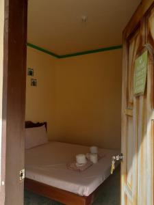 a small bedroom with a bed with two cups on it at Enrico's Guesthouse in Siquijor