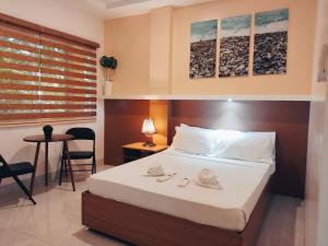 a bedroom with a bed and a table with a chair at Aurelle Inn in Legazpi