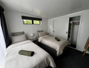 a bedroom with two beds and a window at Pond Road Park - Raglan in Raglan