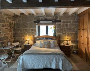 um quarto com uma cama e uma parede de pedra em A XANELA 